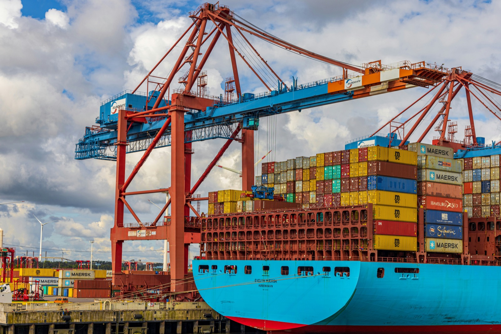 Container ship being unloaded by cranes at port