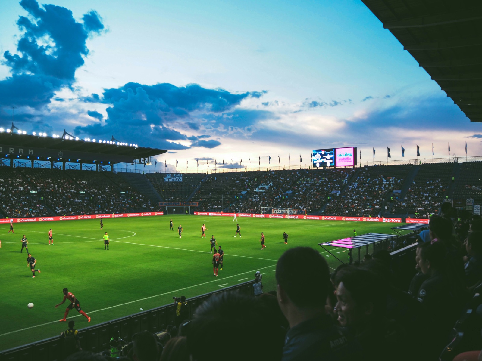 Soccer stadium at dusk with crowd in stands